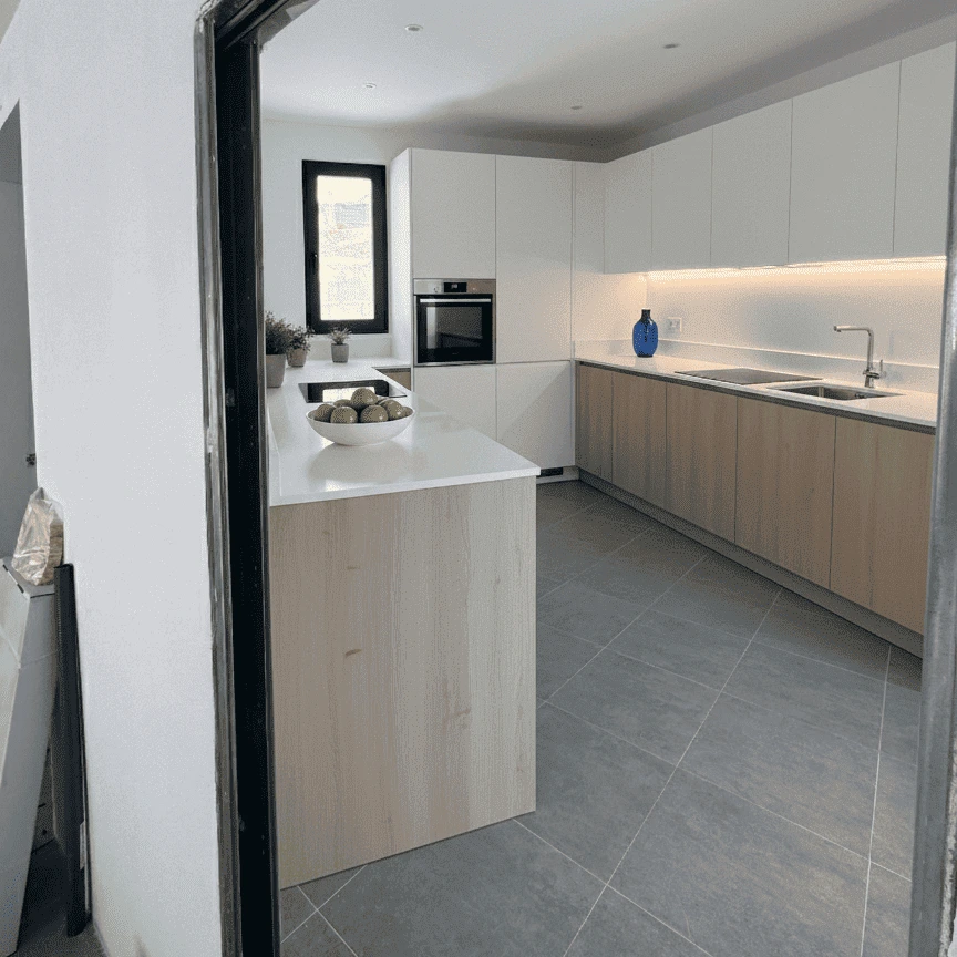 Cocina moderna con acabados en blanco y madera. Proyecto de reforma e interiorismo de alto nivel.